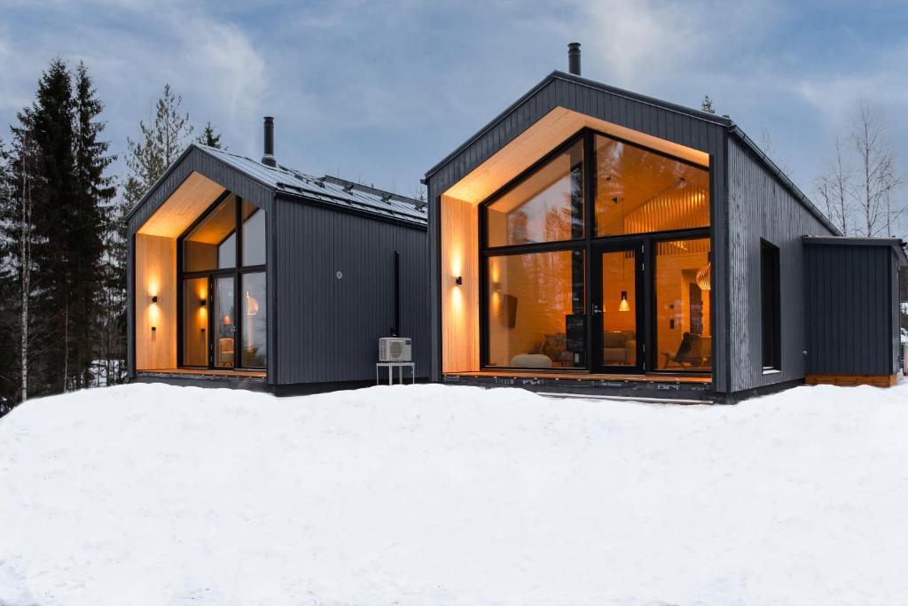 a black house with large windows in the snow at Vuokatti Weekend Platinum in Vuokatti