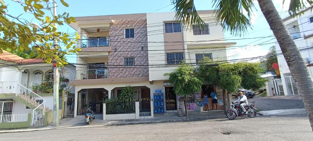 a building on the side of a street with motorcycles parked outside at HEA Stays II in San Felipe de Puerto Plata