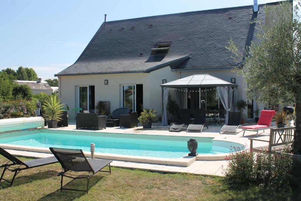 a swimming pool in front of a house at Le Champ De La Ferme in Saint-Gervais en-Belin