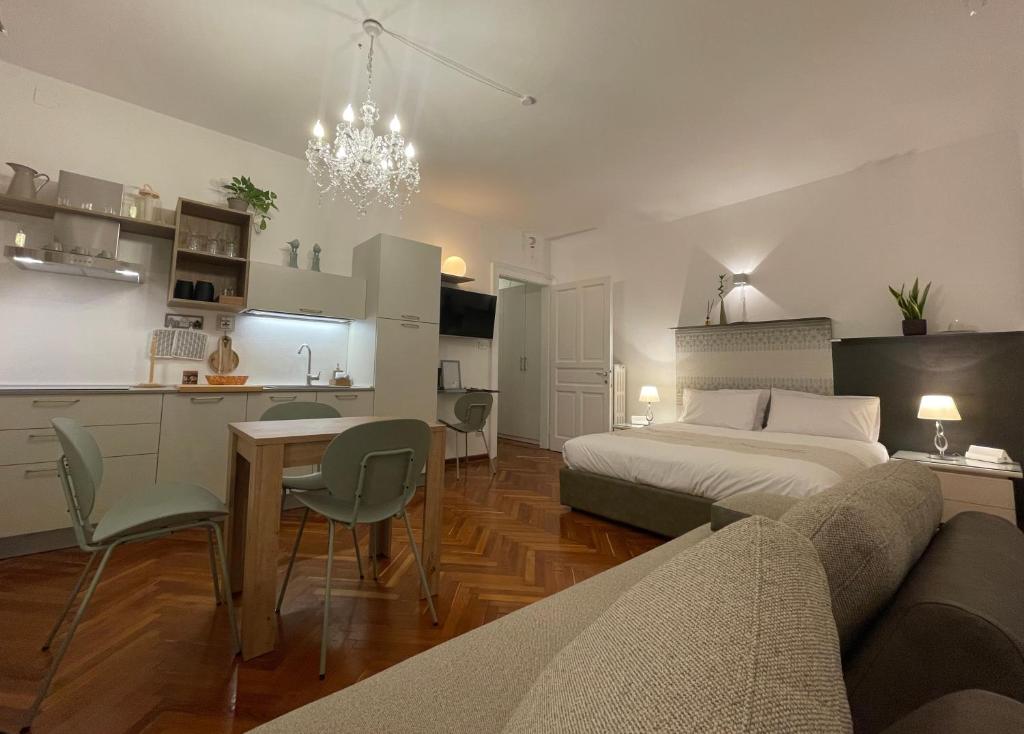 a bedroom with a bed and a table and a kitchen at La Suite dei Cristalli - Gorizia Central Apartment in Gorizia
