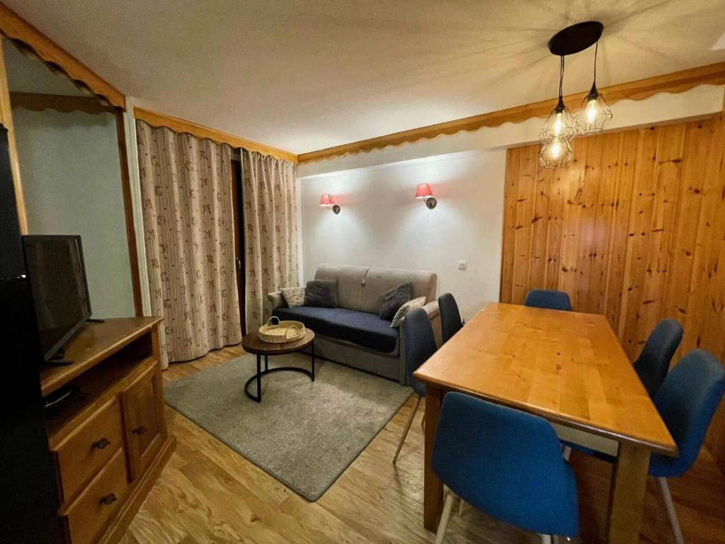 un salon avec un canapé bleu et une table dans l'établissement Résidence Les Eglantines - 2 pièces 6 personnes place centrale les Orres 1800 MAE-2811, aux Orres