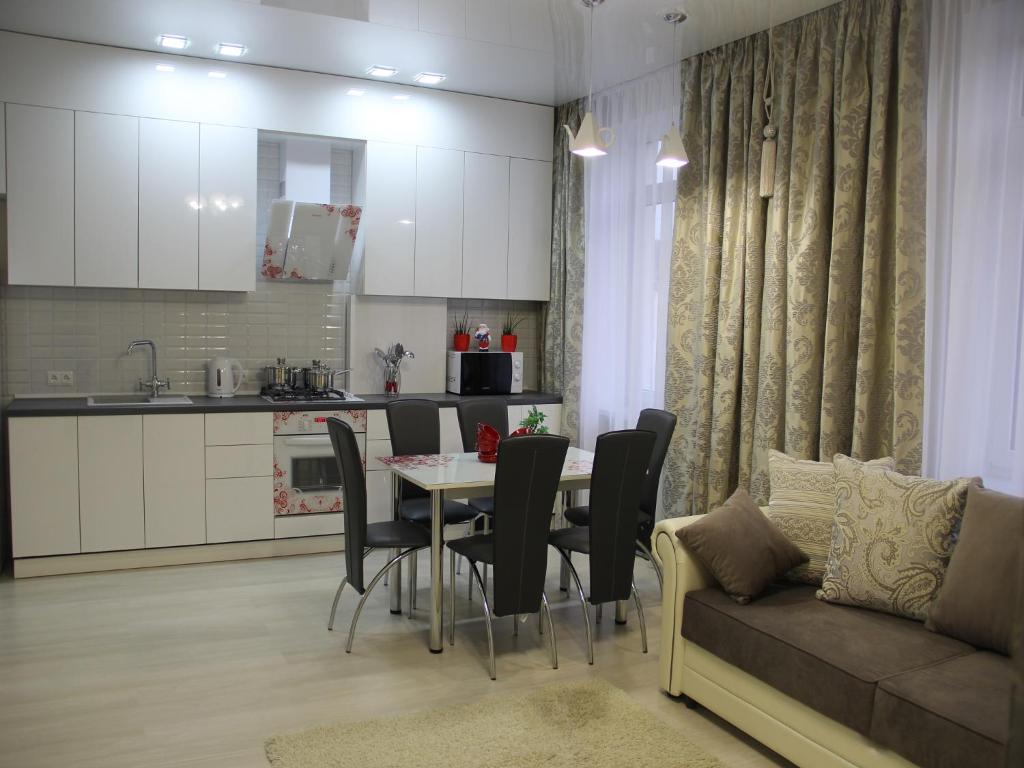 a kitchen and living room with a table and a couch at City Life Apartments on Pushkinskaya in Brest