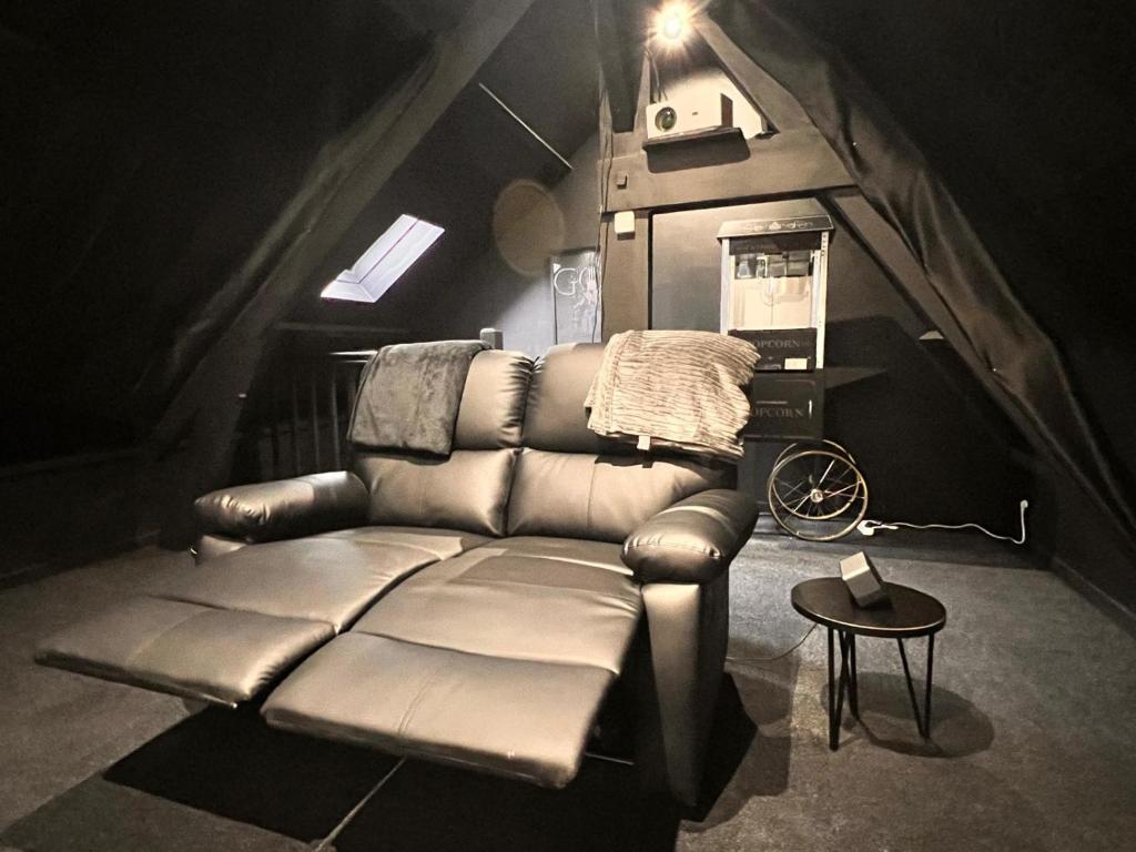 un salon avec un canapé en cuir et une table dans l'établissement BLK Room Cinema, à Boulogne-sur-Mer