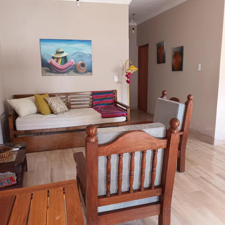 a living room with a bed and a chair at Cabañas Tafi in Tafí del Valle