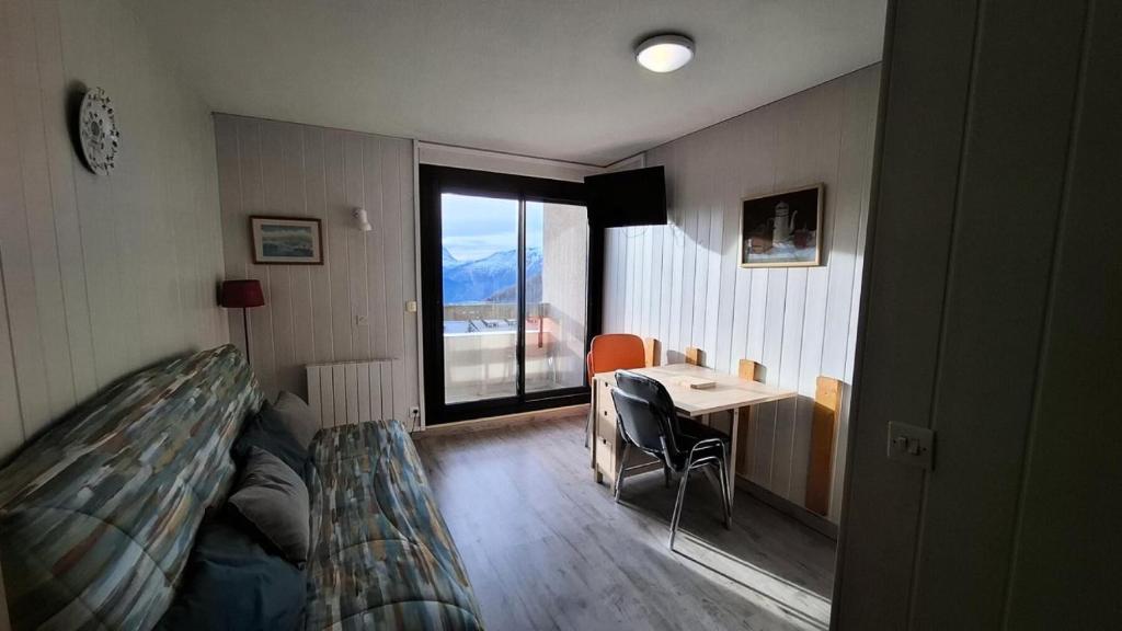 une chambre avec un lit, une table et une fenêtre dans l'établissement Résidence Soleil D'huez - APPARTEMENT ALPE D'HUEZ QUARTIER DE L'ECLOSE EST MAE-3331, à Huez
