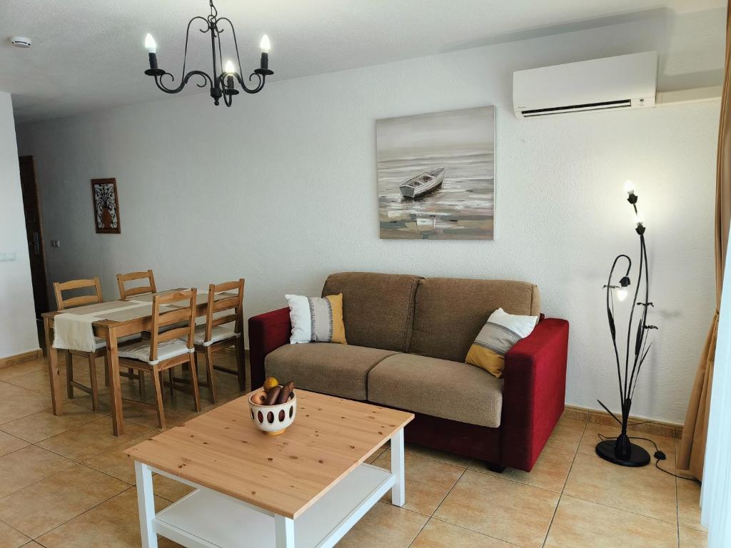 una sala de estar con un sofá y una mesa en FAIRWAYS CLUB, suite B37, en San Miguel de Abona