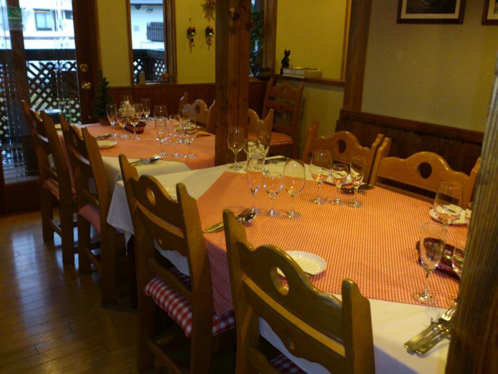 un comedor con una mesa con copas de vino en North Point Lodge, en Minami Uonuma