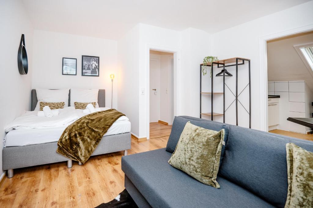 a living room with a blue couch and a bed at Artful Apartment in Krefeld