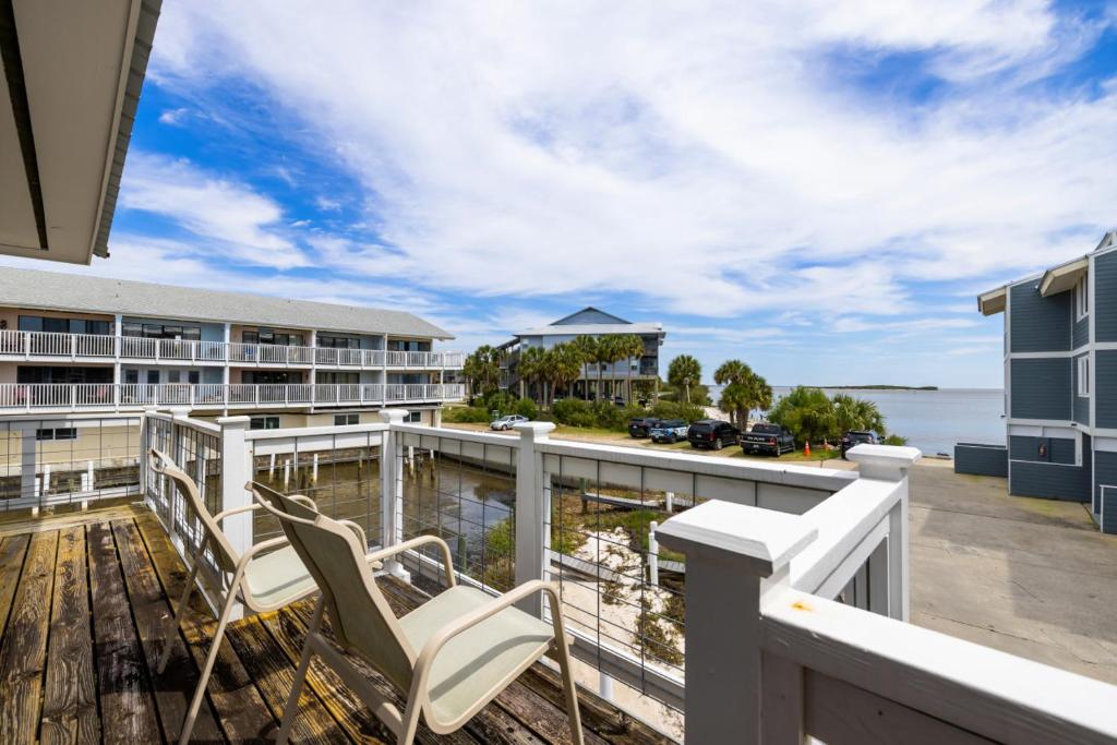 a balcony with chairs and a view of the ocean at Cove Cottage - Gulf front stilt home in Cedar Key