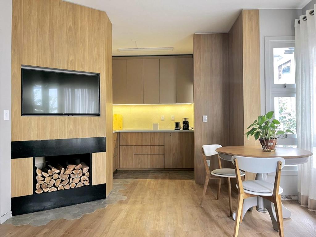 a kitchen with a fireplace and a table and chairs at Espaço Lola - a 500 mts da Rua Coberta in Gramado