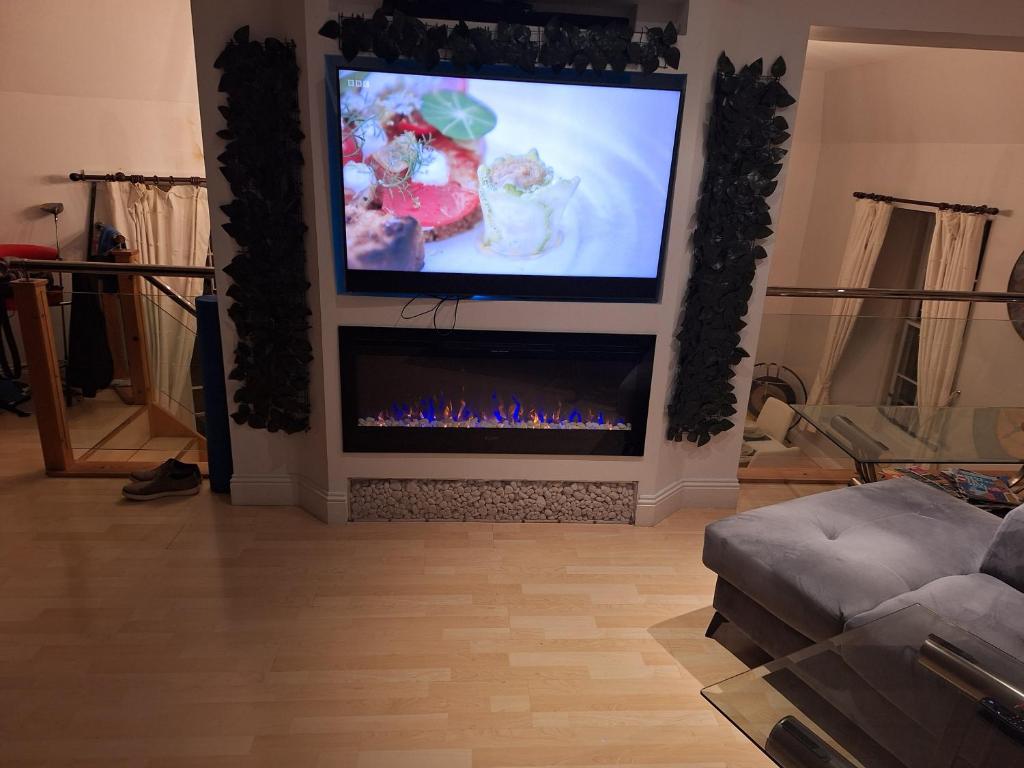 a living room with a tv and a fireplace at Townhouse with 3 bathrooms in Edinburgh