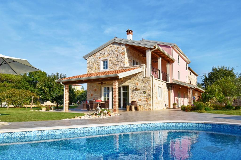 una casa con piscina delante de una casa en Villa Manuela by Rent Istria, en Babići