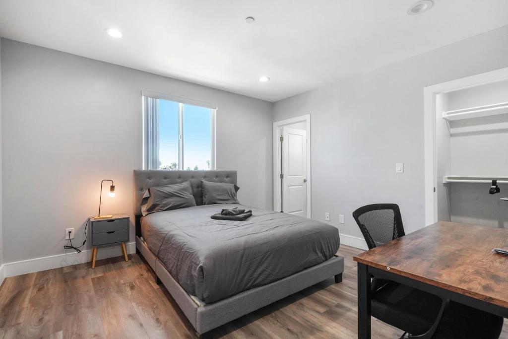 ロサンゼルスにあるModern Bedroomのベッドと机とテーブルのある寝室