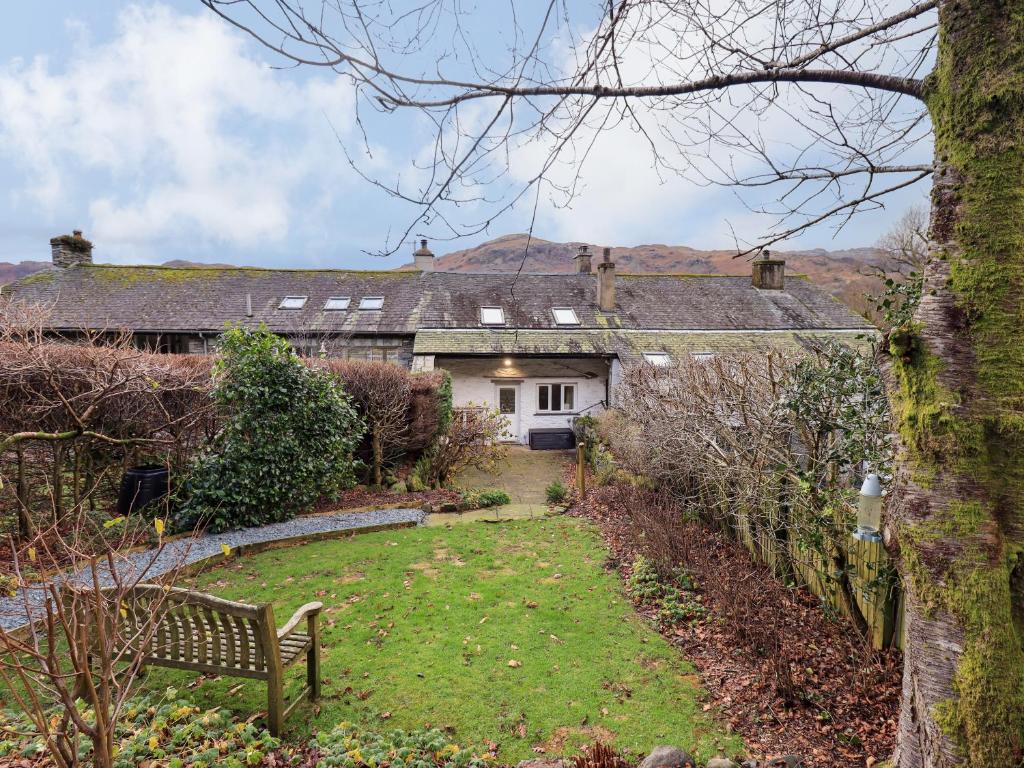 ein Haus mit einer Bank davor in der Unterkunft Daisy Cottage in Grasmere