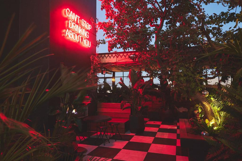 a restaurant with a checkered floor and red neon signs at STILE Downtown Los Angeles by Kasa in Los Angeles