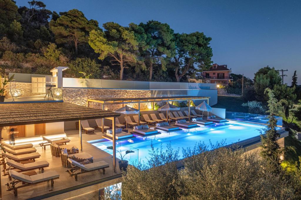 an image of a pool with chairs and a house at Myzith Luxury Suites in Keri