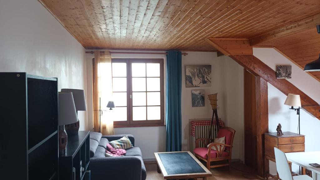 un salon avec un canapé et une fenêtre dans l'établissement charmant t2 montagne, à Saint-Hilaire