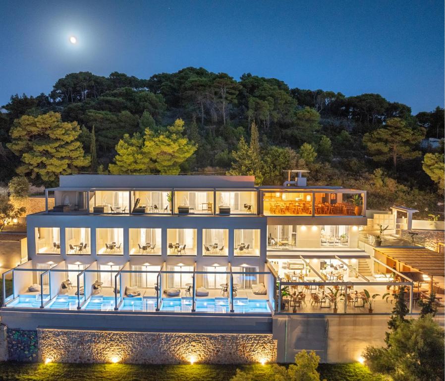 a large white building with a balcony at night at Myzith Luxury Suites in Keri