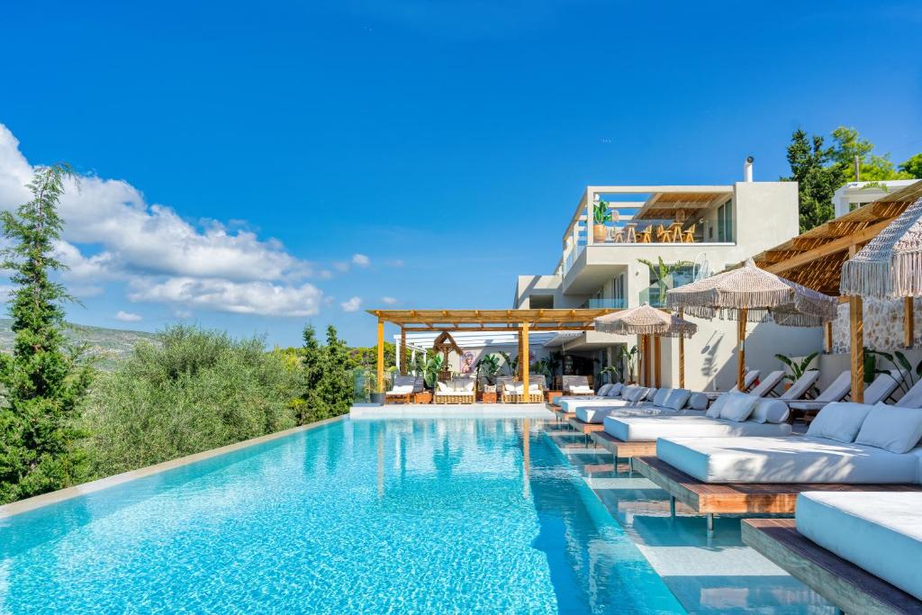 a villa with a swimming pool and lounge chairs at Myzith Luxury Suites in Keri
