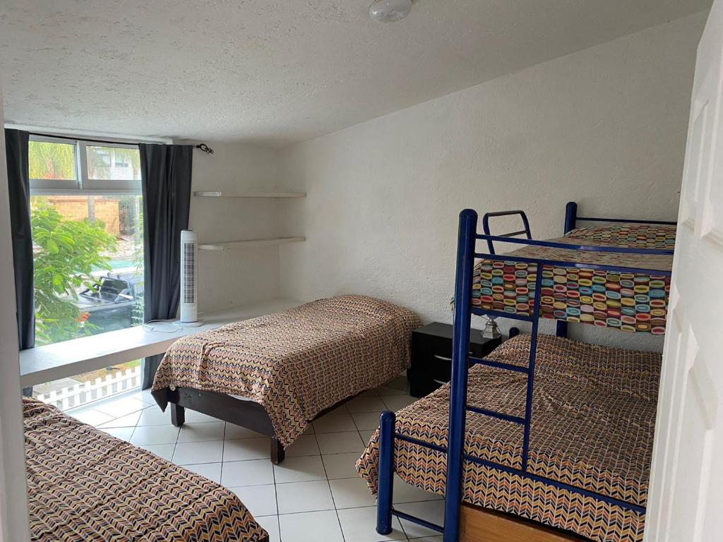 a room with two bunk beds and a window at Casa con Alberca para 12 personas en Club de Golf el Cristo in Atlixco