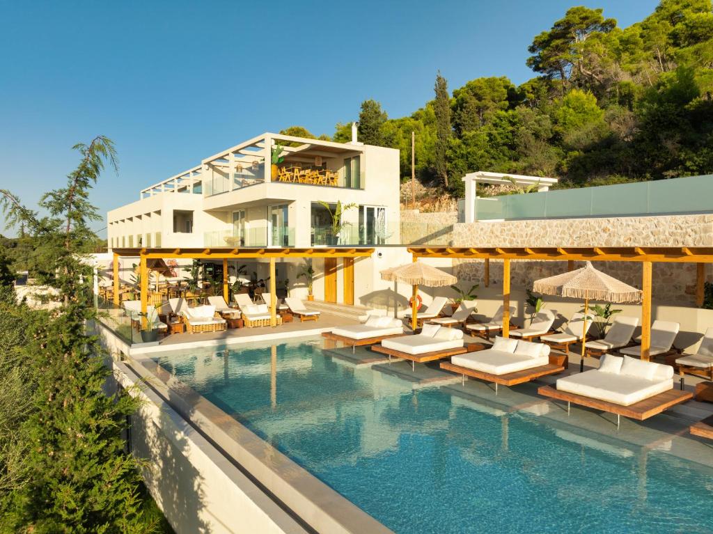 a resort with a swimming pool with chairs and a building at Myzith Luxury Suites in Keri