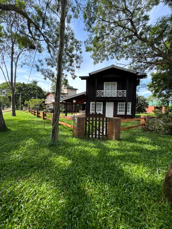 a house on a green lawn with trees at Hermosa casa en Country Rincon Ituzaingo in Ituzaingó