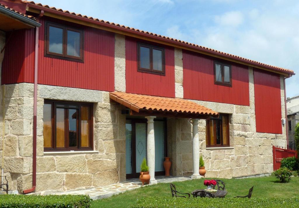 ein rotes und weißes Haus mit einem Fahrrad davor in der Unterkunft Hotel A Palleira in Allariz