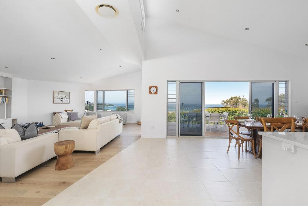 a living room with white furniture and a table at Riverleigh, Gerroa in Gerroa
