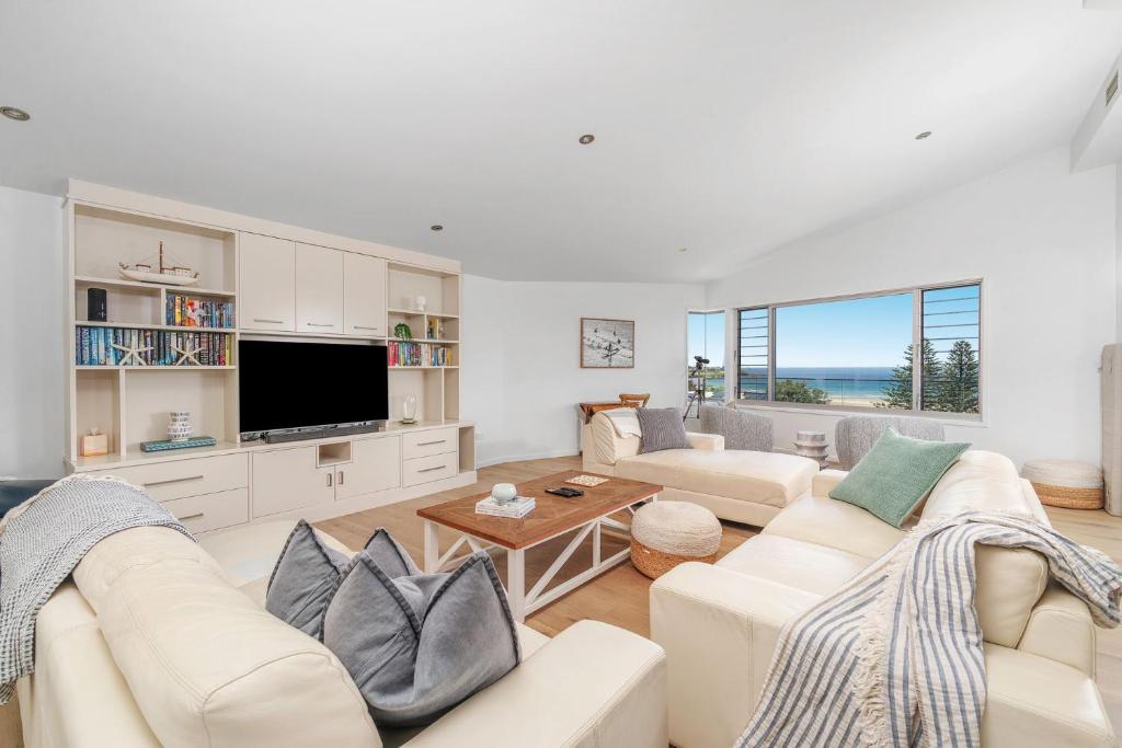 a living room with a couch and a tv at Riverleigh, Gerroa in Gerroa
