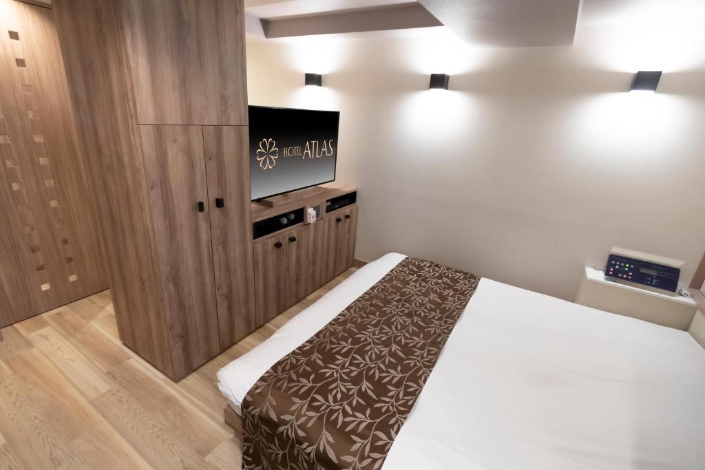 Postel nebo postele na pokoji v ubytování HOTEL ATLAS Shinkabukicho (Adult Only)