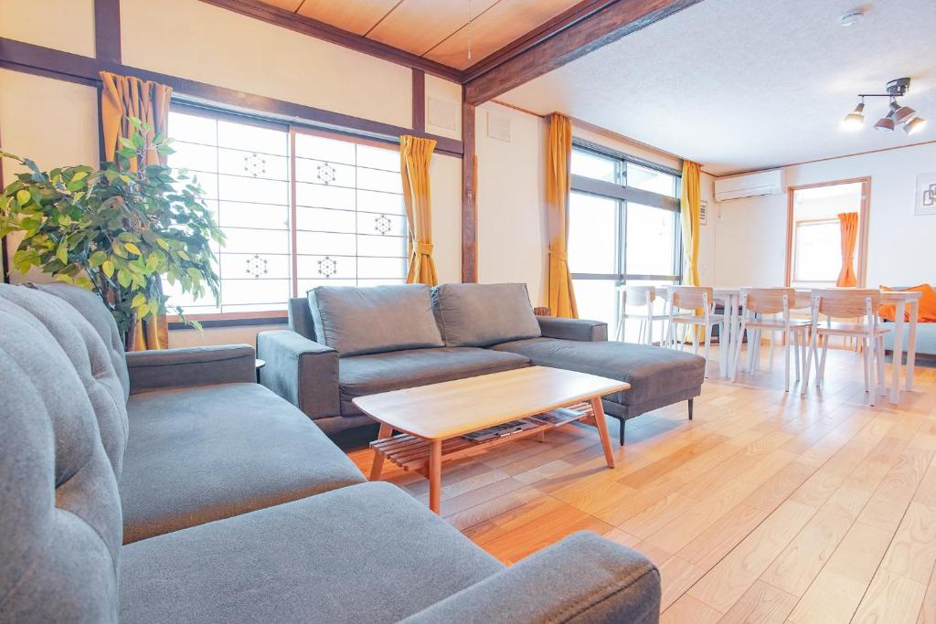 a living room with couches and a table at South Furano House in Furano