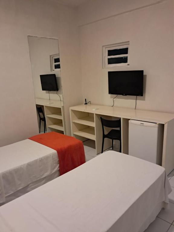レシフェにあるPousada Recife Tropicalのベッドが2つと机とコンピューターがある部屋