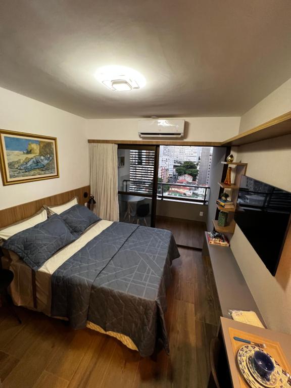 Un dormitorio con una cama y una ventana grande. en Turismo & Business ! Piscina com vista mar, rooftop, academia e praia, en Salvador