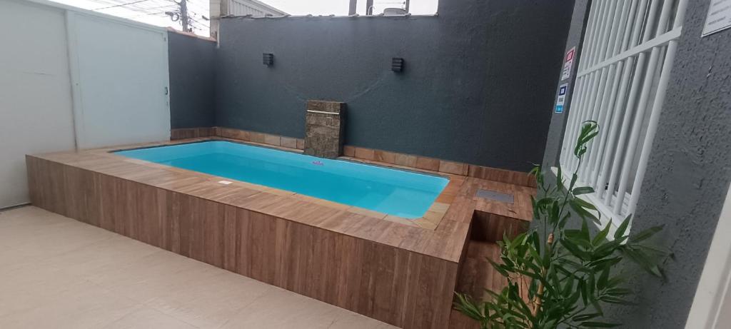 a bath tub in a room with a swimming pool at Casa de praia in Praia Grande