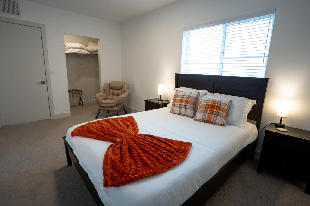 a bedroom with a bed with a red blanket on it at Beehive Haven in Salt Lake City