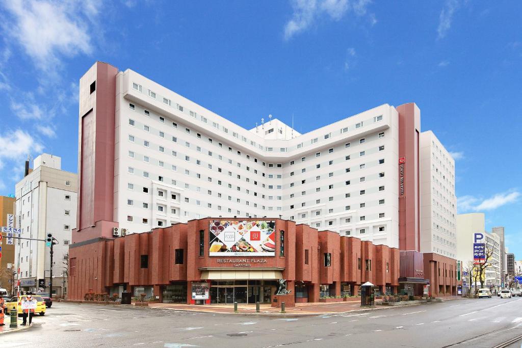 un grande edificio bianco su una strada cittadina di Sapporo Tokyu REI Hotel a Sapporo