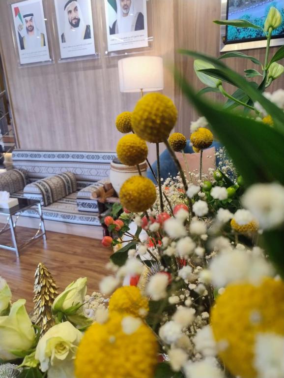 a living room filled with lots of yellow and white flowers at AG Hotel in Abu Dhabi