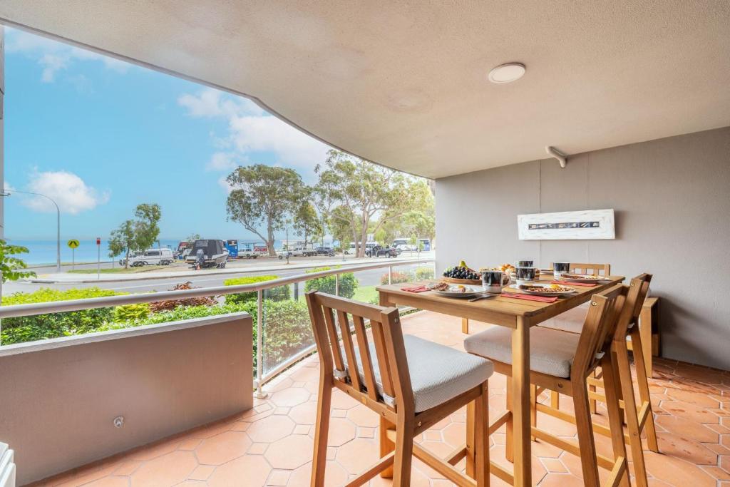 a dining room with a table and chairs and a balcony at Florentine 3, 11 Columbia Cl - Air Con and Sensational Waterviews in Nelson Bay