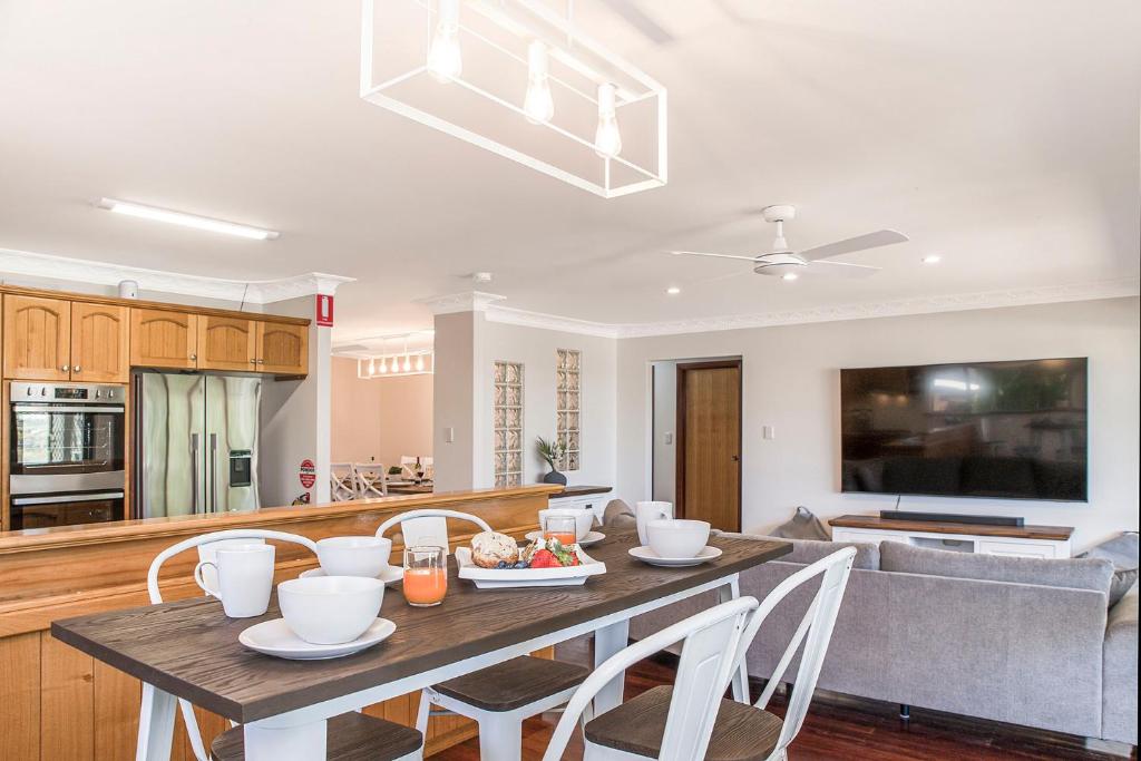 a kitchen and living room with a table and chairs at Moore than a Shack in Guilderton
