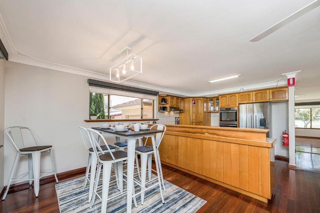 a kitchen with wooden cabinets and a table and chairs at Moore than a Shack in Guilderton