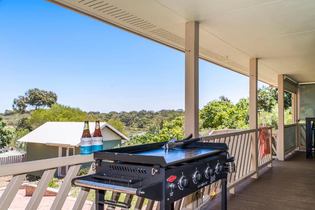 a grill on a porch with two bottles of beer at Moore than a Shack in Guilderton