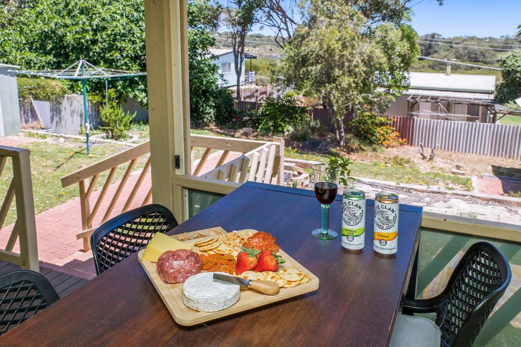 a table with a plate of food and a glass of wine at Moore than a Shack in Guilderton