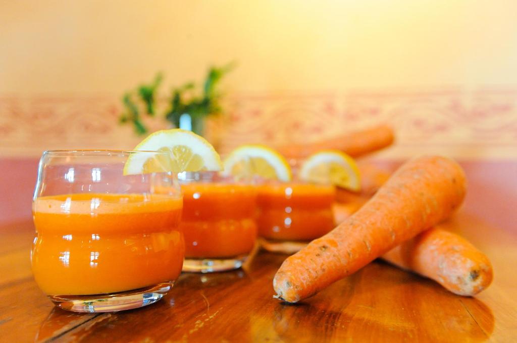 a group of carrots and glasses of orange juice at EcoHotel L’Aubier in Montézillon