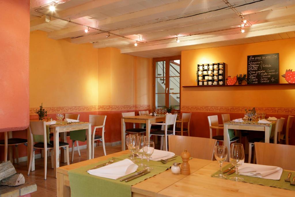 a dining room with tables and chairs in a restaurant at EcoHotel L’Aubier in Montézillon