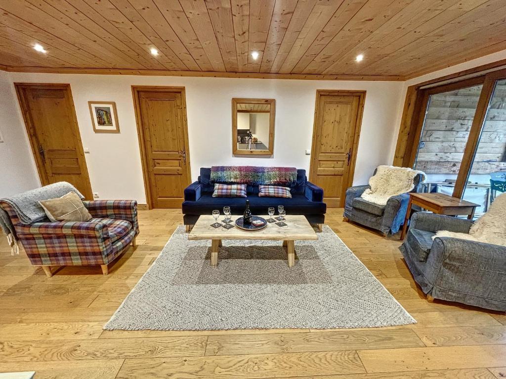 un salon avec un canapé bleu et une table dans l'établissement Jardin Darnica - appartement - 6pers-proche piste, aux Gets