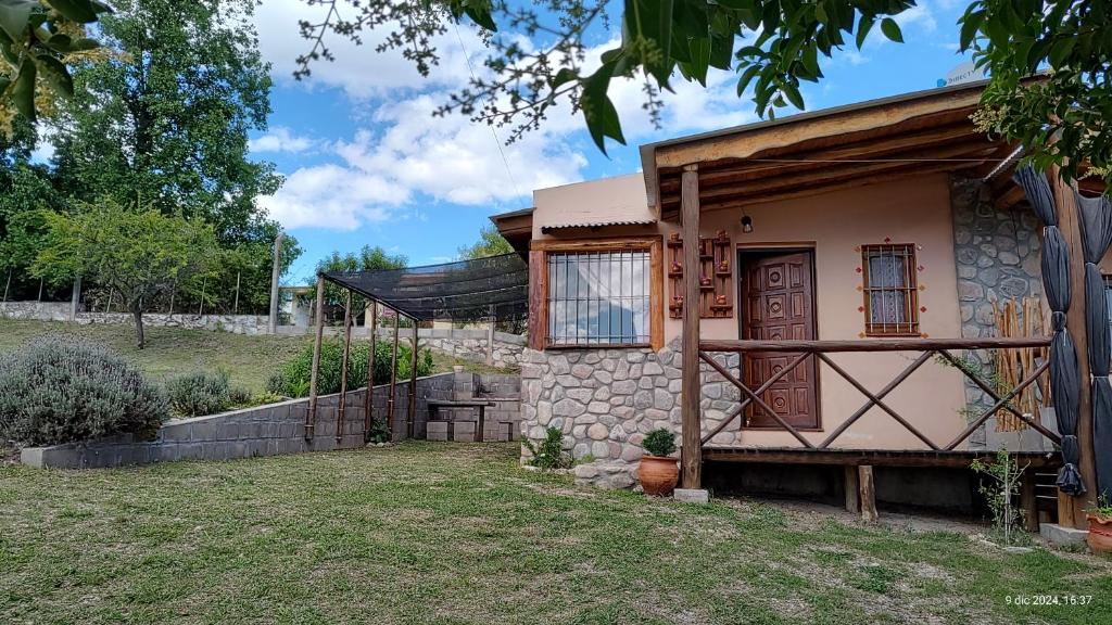 une petite maison avec un mur de pierre dans l'établissement Cabañas Mónika III Norte, à Huerta Grande