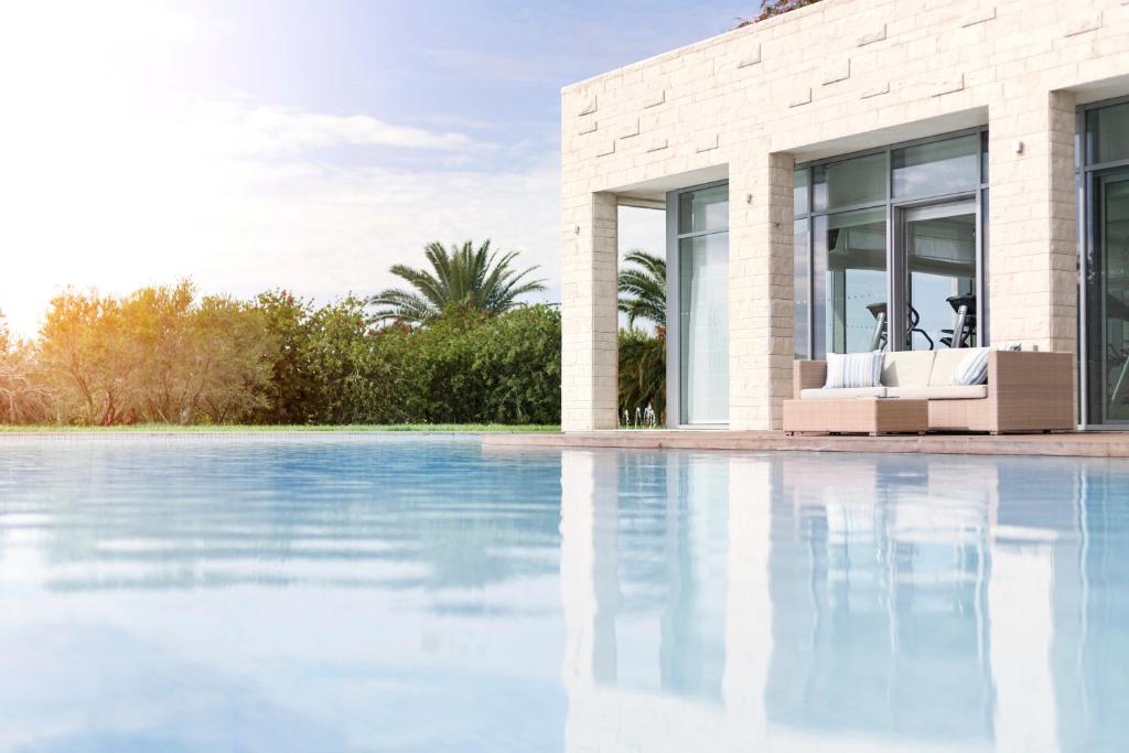 a house with a swimming pool next to a building at Sun Gardens Dubrovnik in Dubrovnik