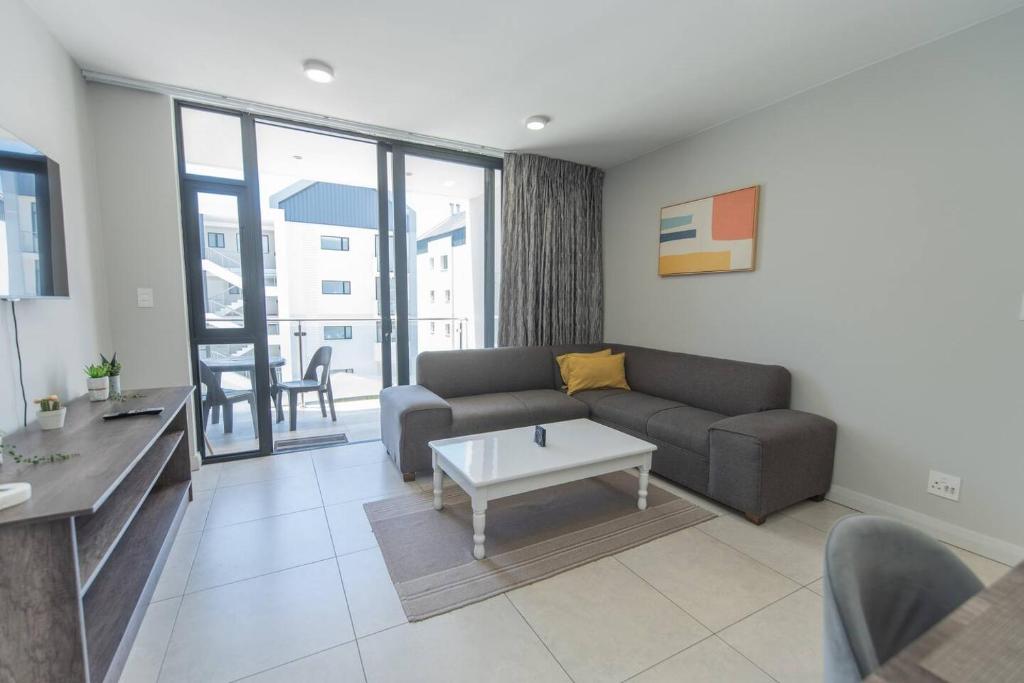 a living room with a couch and a table at Just Beachy Bellamare Apartment in Summerstrand