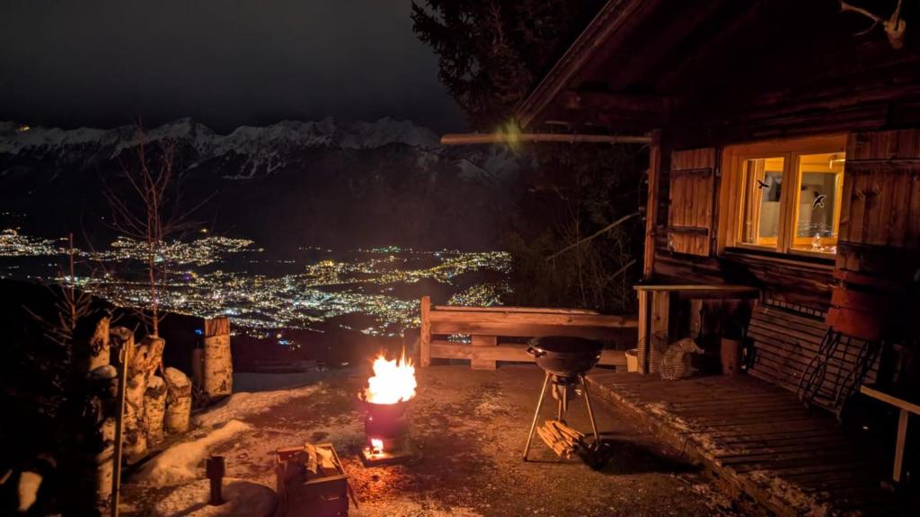a fire pit in front of a cabin at night at Walters Hütte in Tulfes