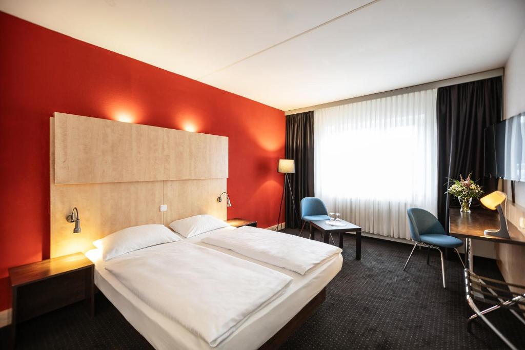 una habitación de hotel con una cama y un escritorio en Good Morning + Bad Oldesloe, en Bad Oldesloe
